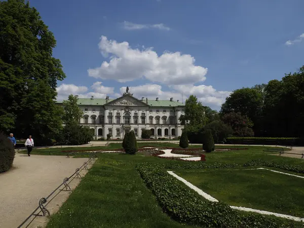 Saray bahçelerinin panoramik manzarası resmi peyzaj ve mimari uyumu gün ışığında sergiliyor.
