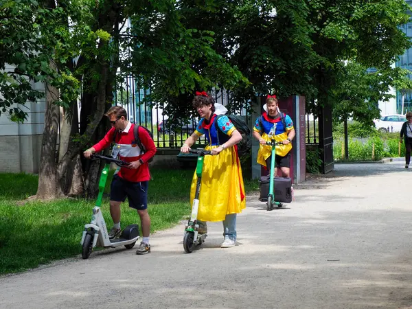 Ortaçağ kostümlü sanatçılar geleneksel dans figürlerini gösterirken, ağaçlarla çevrili kamusal alanda kalabalığı eğlendiriyorlar.