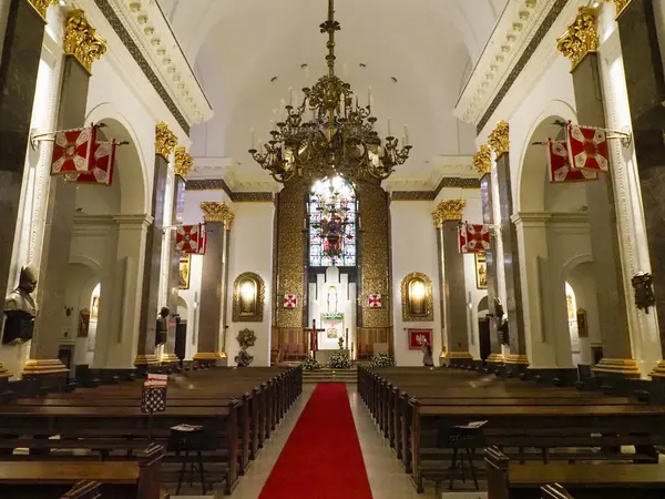 Geleneksel Katolik kilisesinin iç manzarası. Dini tören sırasında süslü barok sunakları ve ahşap sıraları var.