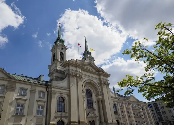 İkiz kuleleri ve beyaz bulutlu dramatik mavi gökyüzüne karşı süslü cepheleri olan tarihi barok kilisesi