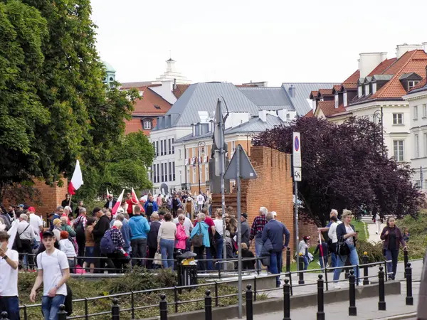 Halk mitingine katılan bayraklı insanlar veya geleneksel Avrupa mimarisi ile tarihi şehir merkezinde yürüyüş