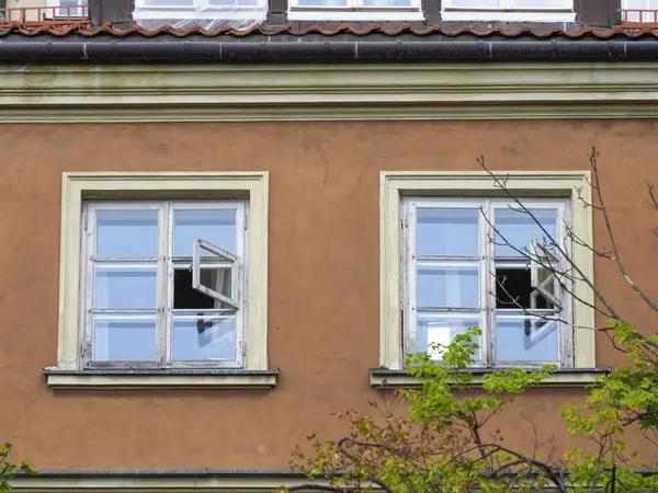 Beyaz çerçeveli pencereleri ve terracotta renkli duvarları olan geleneksel Avrupa konut cephesi