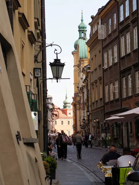 Tarihi binalar ve yayaların geleneksel Avrupa mimarisini araştırdığı Varşova Eski Kasabası 'nda dar bir ortaçağ sokak manzarası