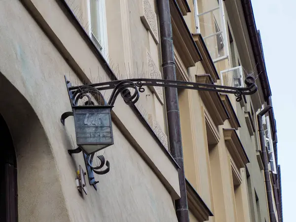 Tarihi dövmeli demir sokak lambası, Varşova Eski Kasabası 'nda inşa duvarına monte edilmiş geleneksel metal işçiliği sergiliyor.