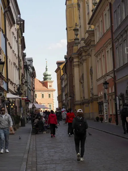 Ortaçağ Avrupa caddesinde tarihi binalar ve yayalar kilise kulesine doğru yürüyor.