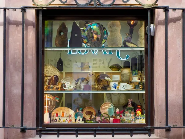 Geleneksel Avrupa mağaza vitrininde gündüz vakti renkli vintage oyuncaklar ve dekoratif eşyalar sergileniyor