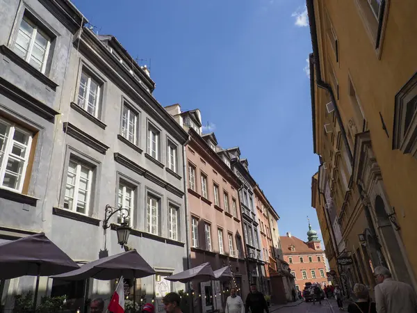 Mavi gökyüzünün altında Avrupa 'nın eski semtindeki kaldırım taşı caddesi boyunca uzanan renkli tarihi konaklar