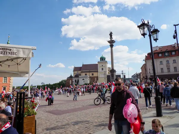 Tarihi Varşova Şato Meydanı dramatik bulutlu gökyüzü altında turistler ve yerel halkla dolup taşıyor