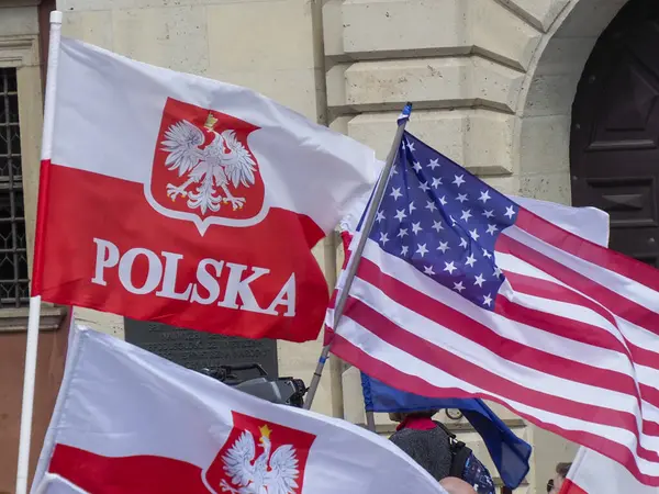 Varşova 'da düzenlenen uluslararası kutlamalarda kartal amblemi ve Amerikan yıldız ve çizgili birden fazla Polonya bayrağı sergilendi.