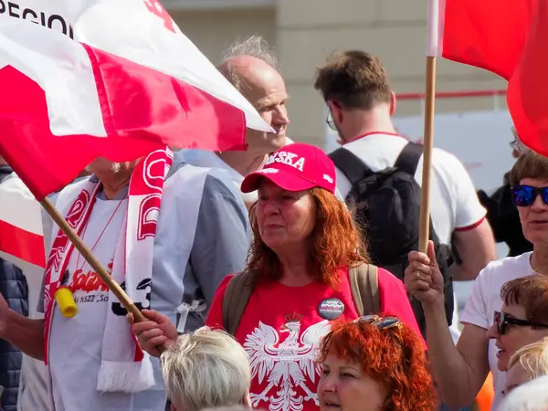 Şehir merkezindeki vatansever kutlamalar sırasında coşkulu Polonya vatandaşları kırmızı ve beyaz bayraklar sallıyor.