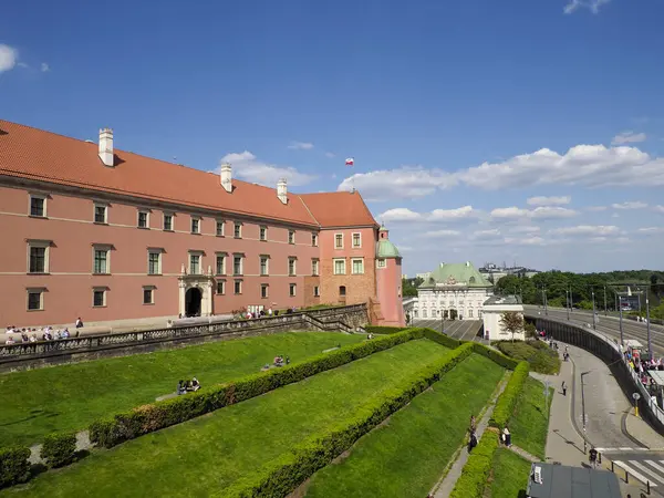 Manikürlü bahçeleri ve parlak yaz güneşinde yürüyen turistleri olan Royal Castle Varşova