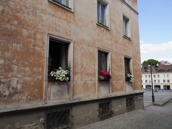 Avrupa sokaklarına bakan pencerelerde dekoratif çiçek kutuları olan büyüleyici mercan renkli bina cephesi