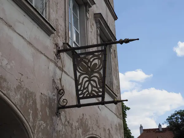 Geleneksel işlenmiş demir sokak lambası tarihi taş bina duvarına monte edilmiştir.