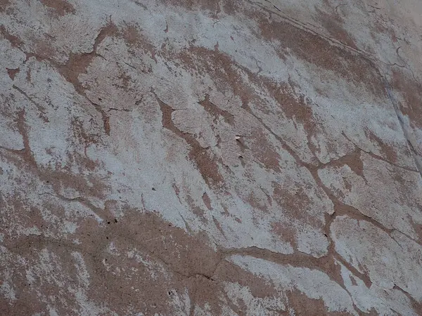 Yıpranmış taş duvar dokusu doğal yaşlanma ve aşınma etkilerini gösteriyor.