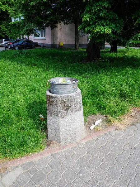 Kamu parkındaki çimlerin üzerine yerleştirilmiş kentsel atık kutusu