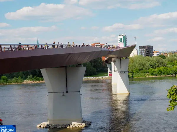 Beyaz kuğu, Vistula Nehri Varşova İlkbahar öğleden sonra beton köprü sütununda zarifçe yüzüyor.