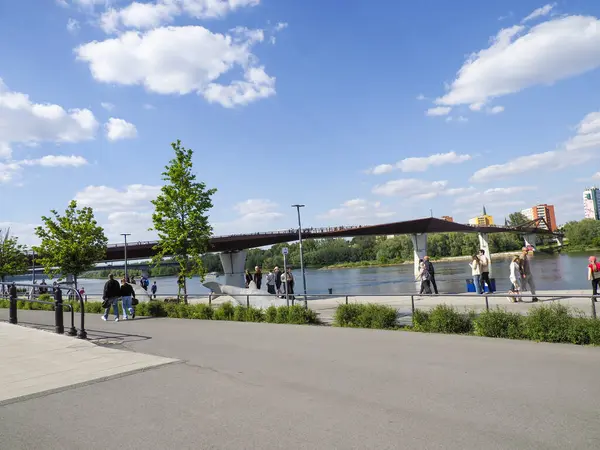 Varşova nehir kenarındaki köprü manzaralı gezintide eğlenen gruplar.