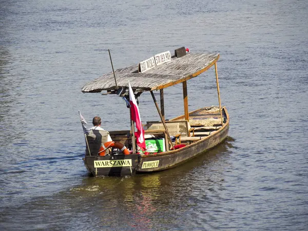 Polonya bayrağıyla geleneksel ahşap turist teknesi ve Varşova yakınlarındaki Vistula sularında nehir turu yapan yolcular.