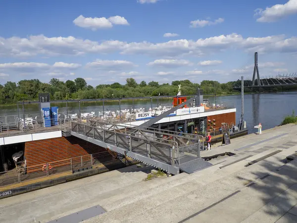 Beyaz teknesi olan yolcu feribot terminali dramatik bulutlu gökyüzünün altında beton iskeleye yanaştı.