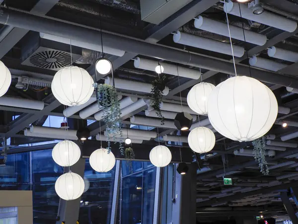 Küresel kolye ışıkları ve atmosferik ışıklandırmalı endüstriyel tavan tasarımına sahip modern restoran iç mimarisi