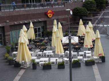 Açık hava restoranının oturma alanını kaplayan çok sayıda sarı şemsiye ticari bölgede gölgeli yemek alanı oluşturuyor.