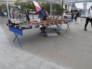 Ulusal kutlama sırasında kaldırımda Polonya bayrakları ve vatansever ürünler satan bir sokak satıcısı.