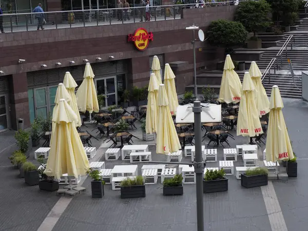 Açık hava restoranının oturma alanını kaplayan çok sayıda sarı şemsiye ticari bölgede gölgeli yemek alanı oluşturuyor.