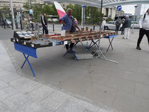 Ulusal kutlama sırasında kaldırımda Polonya bayrakları ve vatansever ürünler satan bir sokak satıcısı.