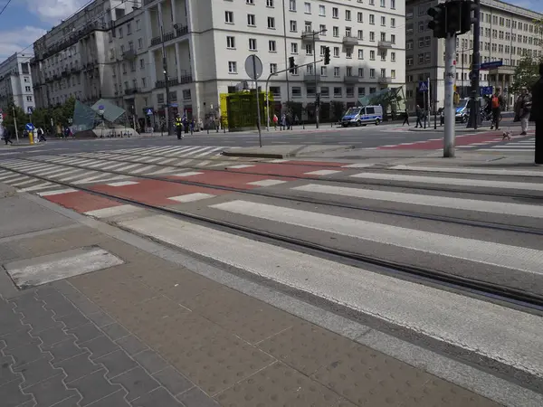 Geometrik desenli ve modern şehir binalarıyla şehir caddesinde boş tramvay rayları doğrusal perspektif oluşturuyor.