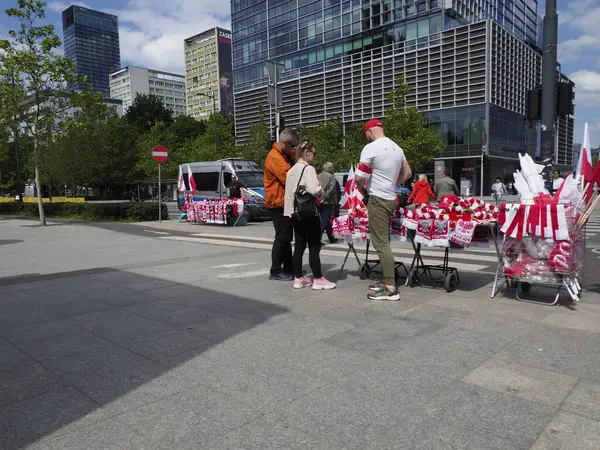 Kırmızı ve beyaz pankartlı Polonyalı protestocular, modern mimariyle çevrili Varşova meydanında barışçıl bir gösteri yaptılar.