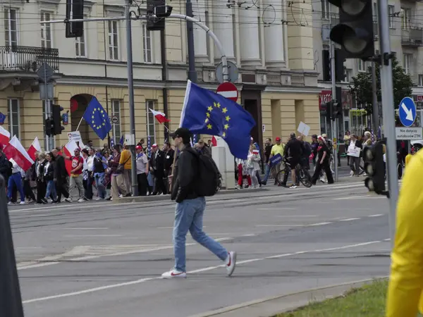 Varşova şehir merkezinde düzenlenen siyasi gösteriler sırasında ellerinde Polonya ve AB bayrakları tutan protestocuların olduğu sokak sahnesi