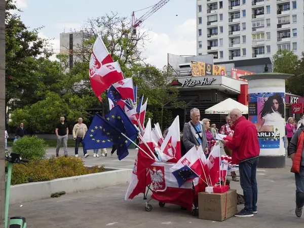 Vatandaşlar, Varşova 'nın merkezinde düzenlenen organize siyasi gösteri sırasında sokak satıcılarından bayraklar satın alıyor.