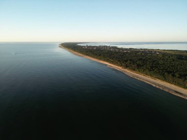 İki su kütlesi arasındaki ağaçlık kıyı şeridinin nefes kesen görüntüsü doğal bir koridor oluşturuyor.