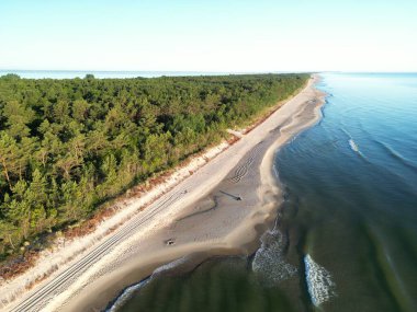 Orman kıyı şeridinin yakınına demirlemiş yatı olan tenha kıyı koyunun yüksek irtifa görüntüsü.