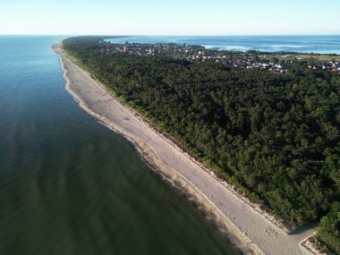 Yoğun orman ve el değmemiş kıyı şeridi arasına kurulmuş muhteşem bir kıyı kasabası manzarası.