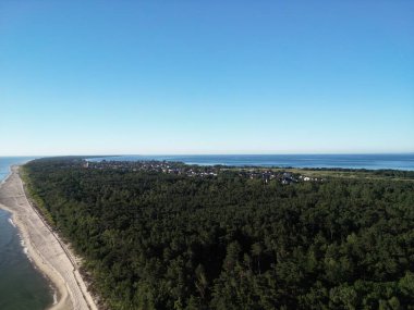 Yoğun orman ve el değmemiş plaj arasına kurulmuş kıyı kasabasının nefes kesici panoramik hava manzarası.