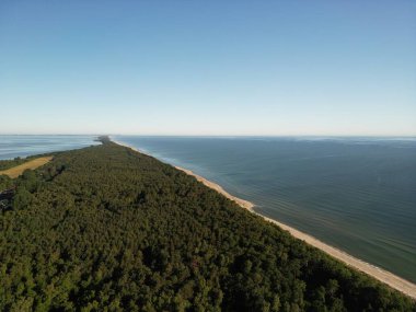Uzamış orman yarımadasının görkemli hava perspektifi yukarıdan görünen dramatik kıyı şeridi kıvrımlarıyla derin mavi deniz sularına doğru ilerliyor.