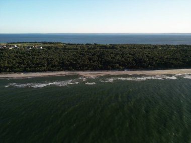 Zümrüt suların beyaz kumlu sahil ve orman manzarasıyla buluştuğu el değmemiş kıyı şeridinin dramatik hava manzarası.