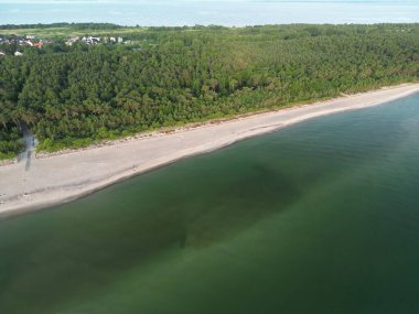 Zümrüt yeşili sularla buluşan el değmemiş kumsal manzarası sık ormanlarla çevrili.