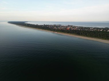 Muhteşem insansız hava aracı, zümrüt ormanının Baltık Denizi 'nin turkuaz sularıyla buluştuğu eğimli kıyı şeridini gösteriyor.