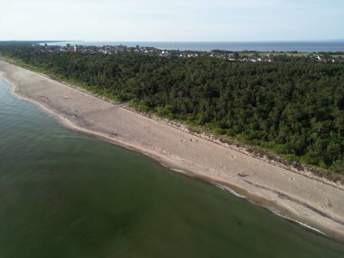Sahil, orman ve yerleşim alanlarının oluşturduğu eğimli kıyı şeridinin hava panoramik görüntüsü doğal sınırlar yaratıyor.