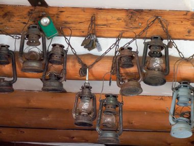 Ahşap tavandan sarkıtılmış antik gaz lambaları atmosferik deniz müzesi sergisi yaratıyor.