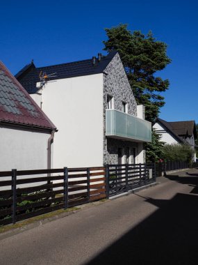 Beyaz evleri ve ahşap çitleri olan geleneksel Polonya iskan caddesi otantik küçük kasaba mimarisini gözler önüne seriyor.