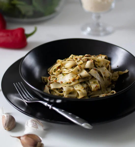 Siyah tabakta ton balığı ve sebzeli İtalyan fettucine makarna.