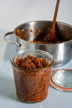 ragu Bolognese also known as Bolognesa or Bolonhesa in a glass jar, on a light background. High quality photo