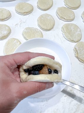 Kişi lezzetli bir hamur işi tutuyor. İçinde yaban mersini ve fıstık ezmesi var. Tatlı ve fındık aromalı lezzetli bir karışım.
