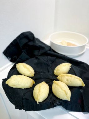 Karıştırma kabının yanındaki siyah bir masa örtüsünde sergilenen çeşitli malzemeler ve yemekler, bir dizi mutfak sergilenmektedir.