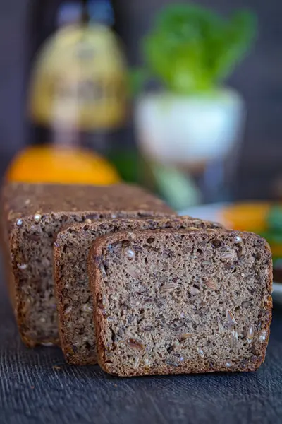 Bir somun ekmek ve iki dilim ekmek bir masaya konur, bu malzemenin çeşitli tariflerde ve pişirilmiş ürünlerde çok yönlü kullanımını gözler önüne serer.