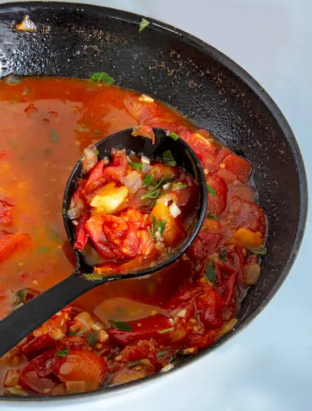 Bir kepçe bir tencere domates sosunu karıştırmak için kullanılır, birçok tabakta anahtar bir bileşendir. Bu lezzetli ve çok yönlü sos makarna, güveç ve deniz ürünleri gibi çeşitli tariflerde kullanılabilir.