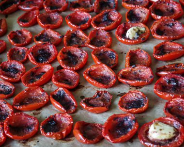 Renklerle birlikte berrak ve çarpıcı dokular sergilenen güzel kavrulmuş kiraz domateslerinden oluşan canlı bir sıra.